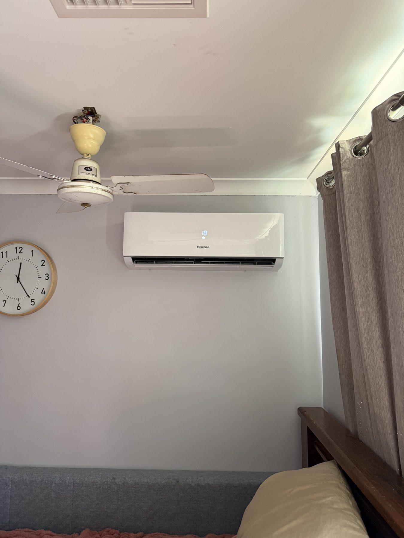 Wall-mounted split system head installed above a bed in a Perth home